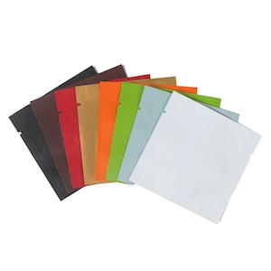 May include: A set of eight colorful, flat pouches with a tear-away top. The pouches are arranged in a fan shape, with the white pouch on top. The pouches are made of a shiny, metallic material.