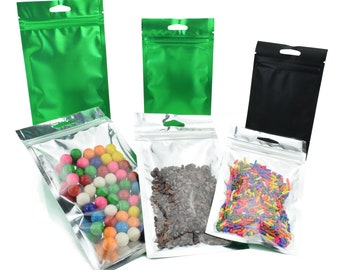 C223 - Paquete de 100 bolsas resellables con cierre térmico, planas, triangulares, con orificio para colgar y lámina metalizada, en color transparente brillante, plateado o mate.