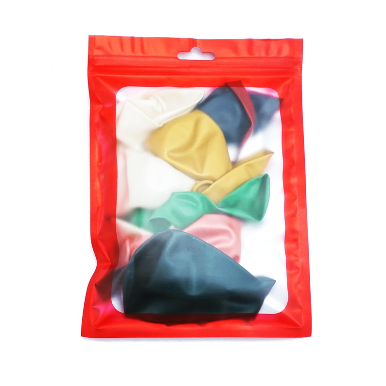 Pu&ograve; includere: Un sacchetto rosso richiudibile con una finestra trasparente che mostra una variet&agrave; di palloncini colorati. I palloncini sono in tonalit&agrave; di verde, blu, rosa, giallo e bianco.
