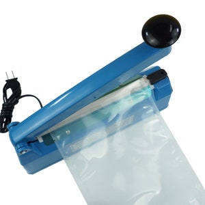 May include: A blue plastic handheld heat sealer with a black handle and a clear plastic bag being sealed. The sealer has a power cord.