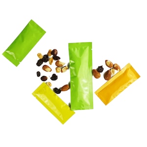 May include: Three small, colorful, stand-up pouches with a white background. The pouches are green, yellow, and orange. The pouches are filled with almonds and raisins.