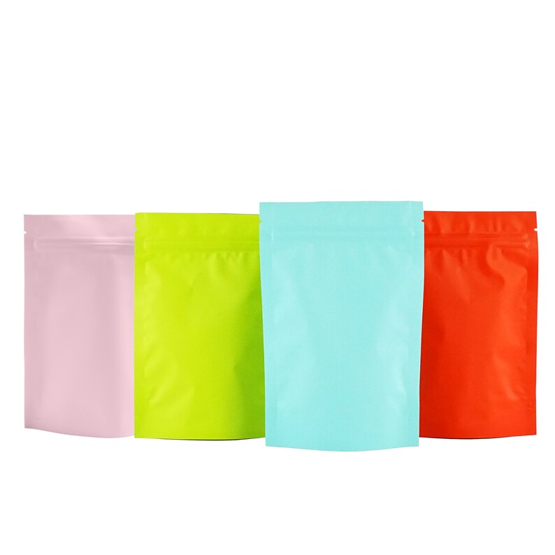 May include: Four stand-up pouches in different colors: pink, green, light blue, and orange. The pouches are made of a shiny, metallic material and have a zipper closure.