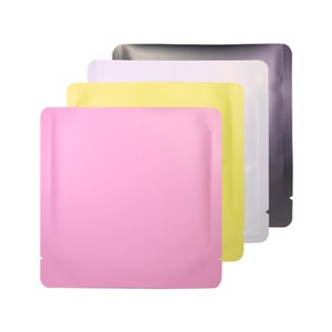 Può includere: Quattro buste stand-up in diversi colori: rosa, giallo, bianco e grigio. Le buste sono realizzate in un materiale lucido e metallico e hanno una chiusura a zip.