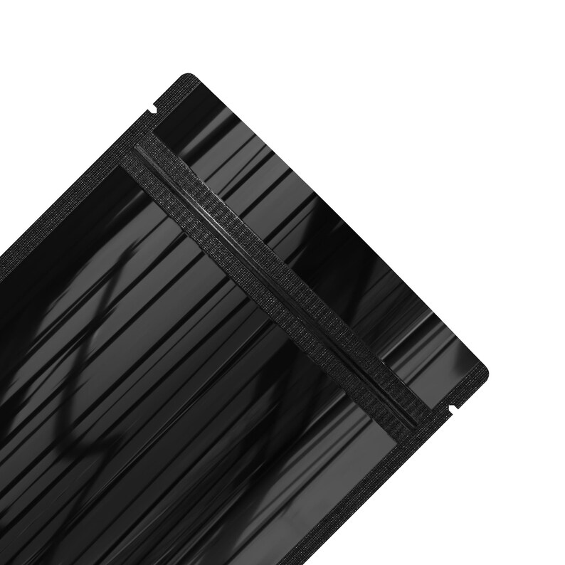 May include: A black stand-up pouch with a zipper closure. The pouch is made of a shiny, metallic material.