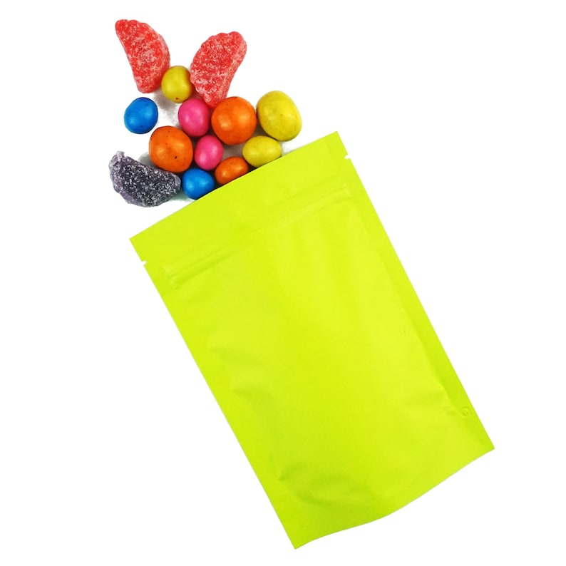 May include: A bright green stand-up pouch with a zipper closure. The pouch is filled with colorful candies, including red, orange, yellow, green, blue, and purple.