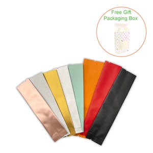 May include: A fan of colorful, sealed pouches in various shades, including rose gold, silver, gold, white, mint green, orange, red, and black. The pouches are arranged in a semi-circle, with a small gift box in the upper right corner.