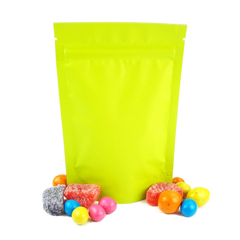 May include: A bright green stand-up pouch with a zipper closure. The pouch is filled with colorful candies, including red, orange, yellow, green, blue, and purple.