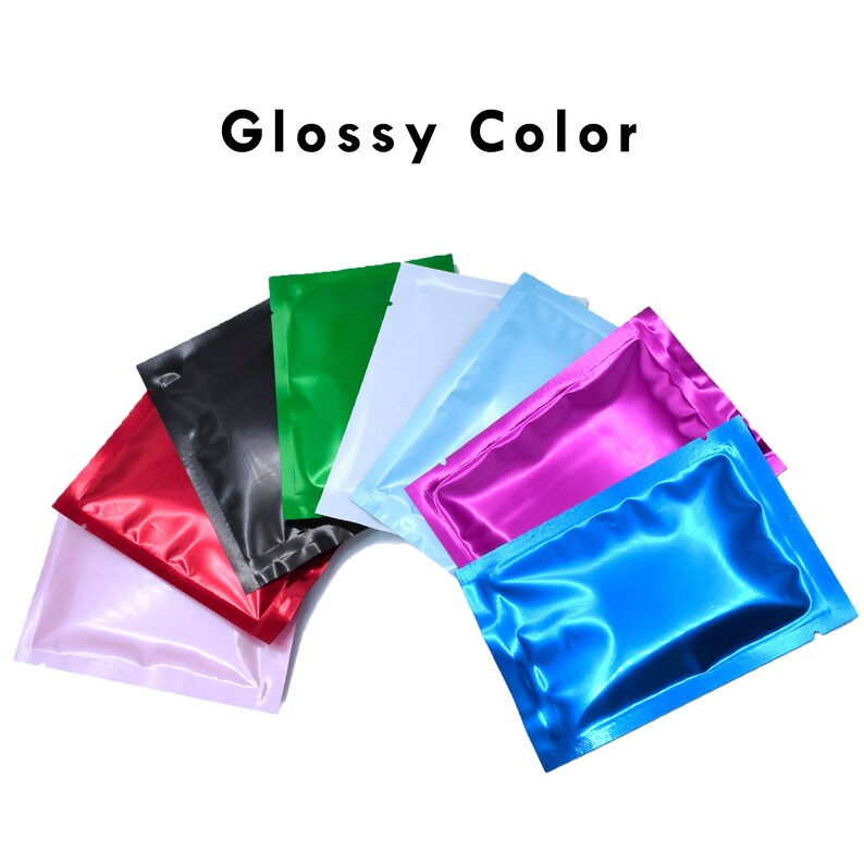 May include: A variety of colorful, glossy, plastic pouches arranged in a semi-circle. The pouches are red, white, green, blue, light blue, and pink.