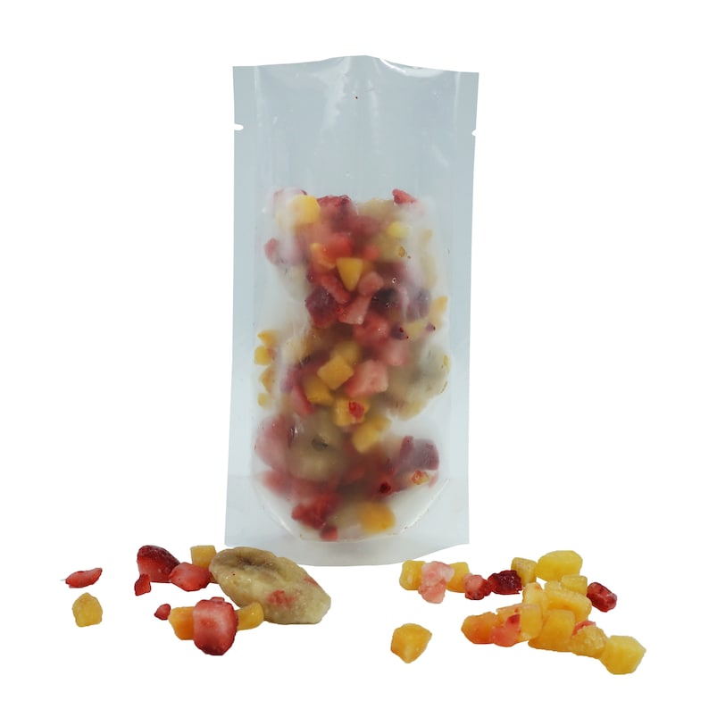 May include: A clear plastic pouch filled with frozen fruit pieces. The fruit is a mix of red strawberries, yellow pineapple, and light brown banana pieces.