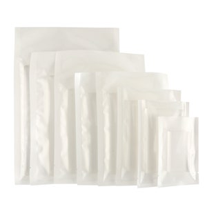 Op de afbeelding: Een set van zes witte plastic staande zakken met een ritssluiting. De zakken zijn van verschillende grootte, met de grootste zak bovenaan en de kleinste zak onderaan.