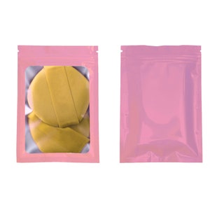 May include: Two pink resealable plastic bags with a clear window. One bag contains two yellow fabric circles.