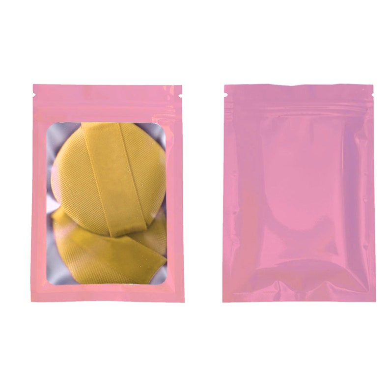 May include: Two pink resealable plastic bags with a clear window. One bag contains two yellow fabric circles.