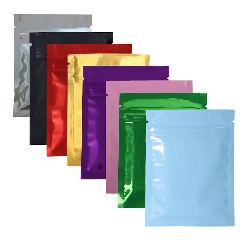 May include: A set of ten stand-up pouches in various colors, including silver, black, red, gold, yellow, purple, pink, green, and light blue. The pouches have a zipper closure and are made of a shiny, metallic material.