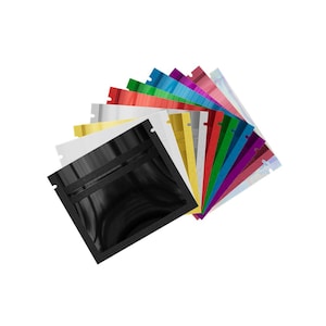 Puede incluir: Una colección de bolsas de mylar resellables de colores, en varios tonos, incluyendo negro, dorado, plateado, rojo, verde y azul. Cada bolsa tiene un cierre de cremallera y está dispuesta en forma de abanico sobre un fondo blanco.