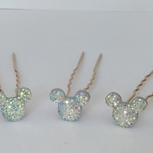 May include: Three gold hair pins with a sparkly silver Mickey Mouse head design.