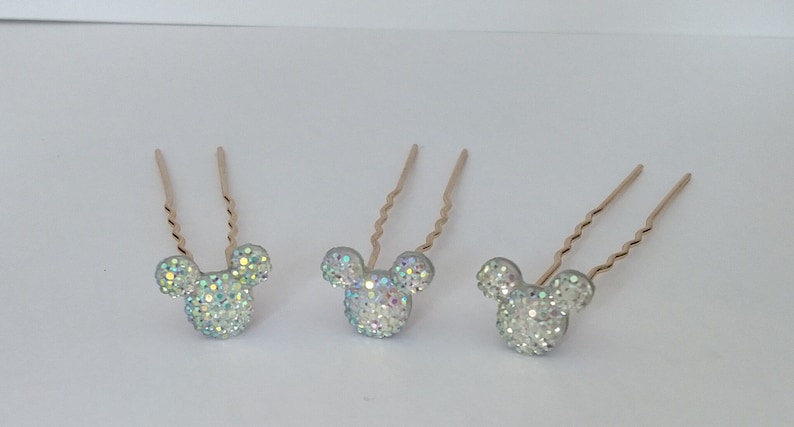 May include: Three gold hair pins with a sparkly silver Mickey Mouse head design.