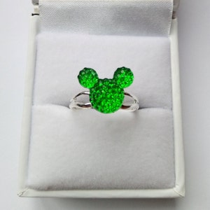 K&ouml;nnte beinhalten: Ein silberner Ring mit einem gr&uuml;nen, glitzernden Mickey Mouse Kopf-Design.