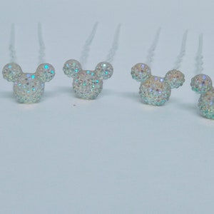 May include: Set of seven iridescent rhinestone Mickey Mouse head hair clips. Each clip has a clear plastic base and a silver wire.