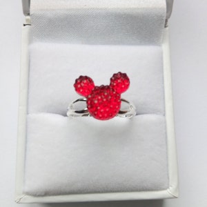 K&ouml;nnte beinhalten: Ein silberner Ring mit einem roten Mickey Mouse Kopfdesign. Der Kopf ist aus kleinen roten Strasssteinen gefertigt.