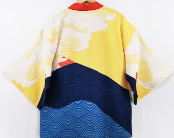 Puede incluir: Un kimono de estilo japonés amarillo, azul y rojo con un patrón de nubes y olas blancas. El kimono tiene un cuello rojo y está hecho de una tela ligera.