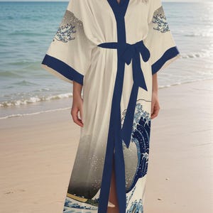 May include: A white silk robe with a blue and gray print of a wave. The robe has a black sash and a V-neck.