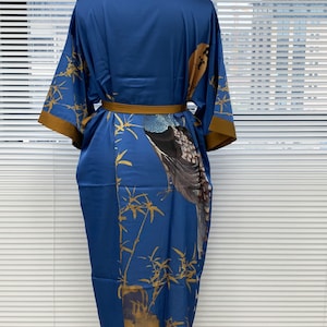 May include: A blue silk robe with a gold and brown bird and bamboo print. The robe has a brown sash.