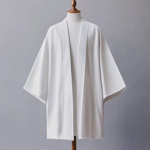 May include: A white lightweight kimono with a simple design. The kimono has long sleeves and a wide, open front.