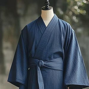 May include: A dark blue, striped, cotton robe with a long sleeve and a sash tie.