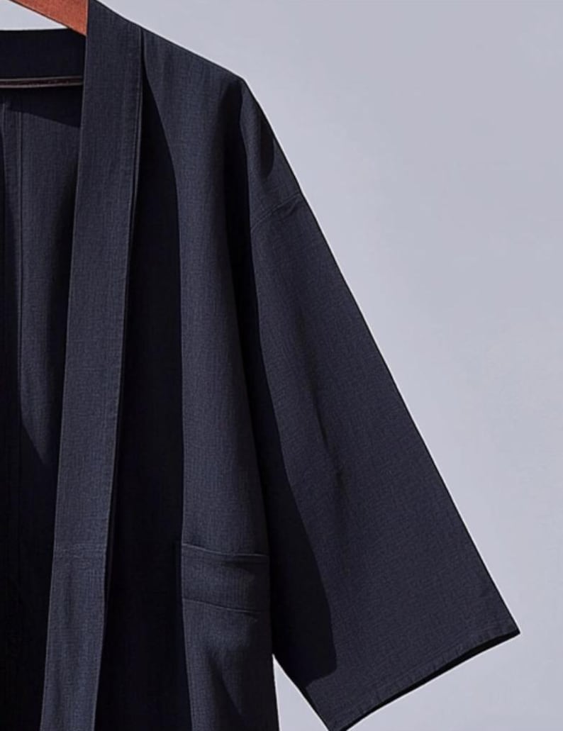May include: A dark blue kimono-style robe with a long, open front and long sleeves. The robe is made of a lightweight fabric and has a simple, elegant design.