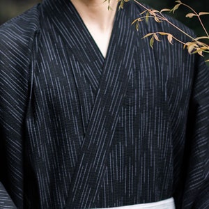 May include: A black and white striped kimono with a white sash. The kimono is made of a lightweight fabric and has a relaxed fit.