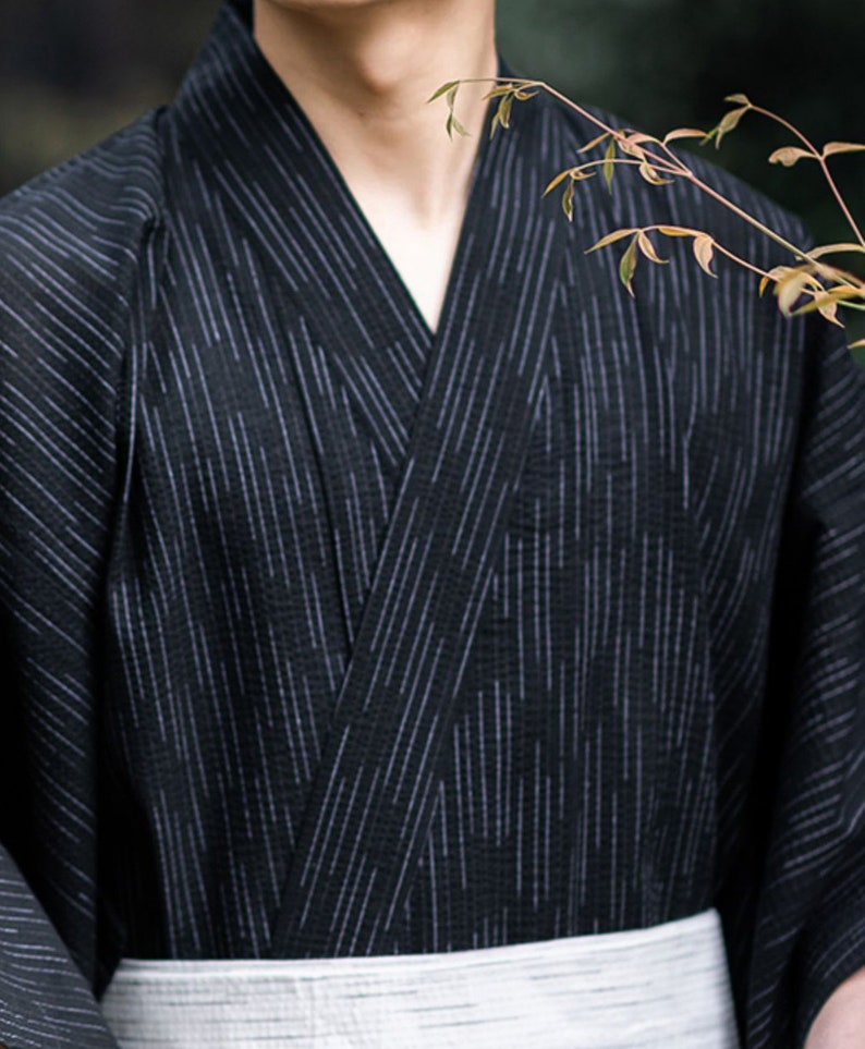May include: A black and white striped kimono with a white sash. The kimono is made of a lightweight fabric and has a relaxed fit.