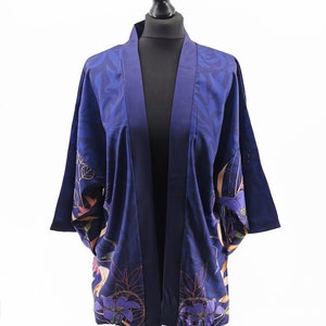 Puede incluir: Un kimono azul marino con estampado floral. El kimono tiene manga larga y cuello ancho.