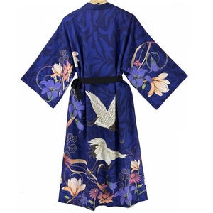 Puede incluir: Una bata de seda azul con estampado floral y de gr&uacute;as. La bata tiene una cinta negra y mangas largas.