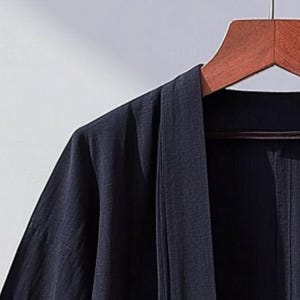 May include: A dark blue kimono-style robe with a long, open front and wide sleeves. The robe is made of a lightweight fabric and has a simple, elegant design.