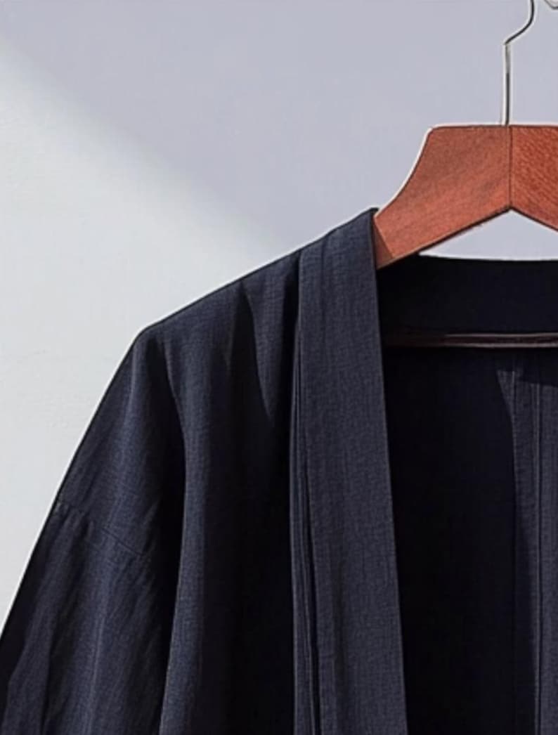 May include: A dark blue kimono-style robe with a long, open front and wide sleeves. The robe is made of a lightweight fabric and has a simple, elegant design.