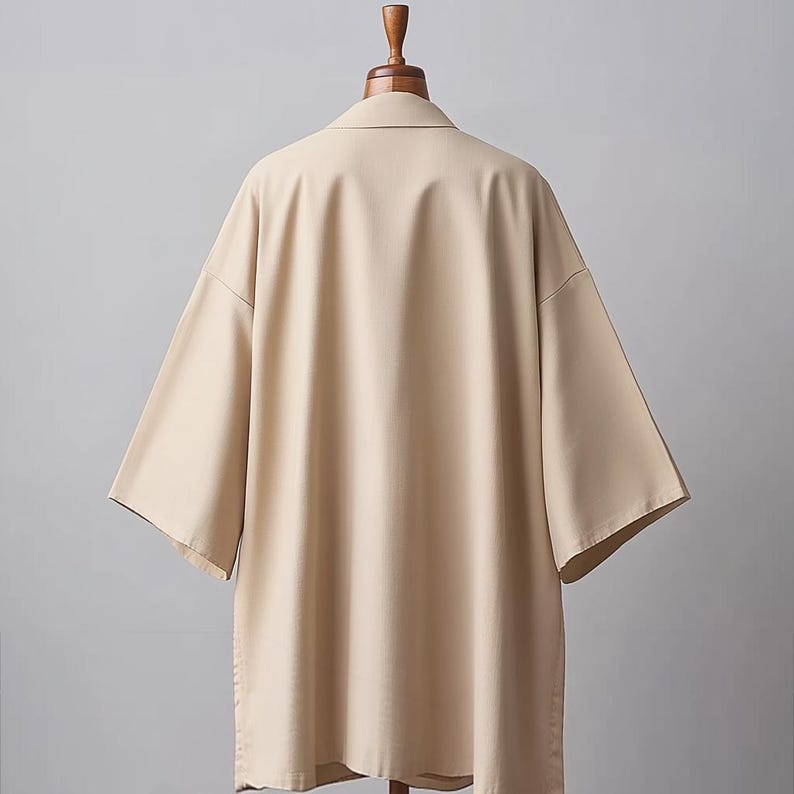 May include: A beige short-sleeved shirt with a collared neckline. The shirt is made of a smooth, lightweight fabric and has a relaxed fit.