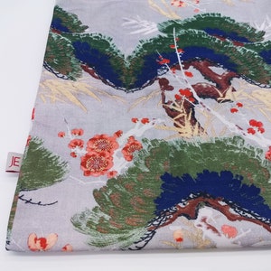 May include: A gray fabric tote bag with a floral print featuring red, white, and green flowers and leaves. The bag has a white background with a subtle texture. The bag has a small red label with the letters "JE" on it.