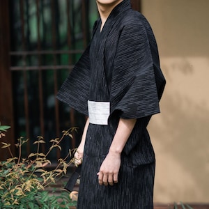 May include: A black and white striped kimono with a white sash. The kimono is made of a lightweight fabric and has a relaxed fit.