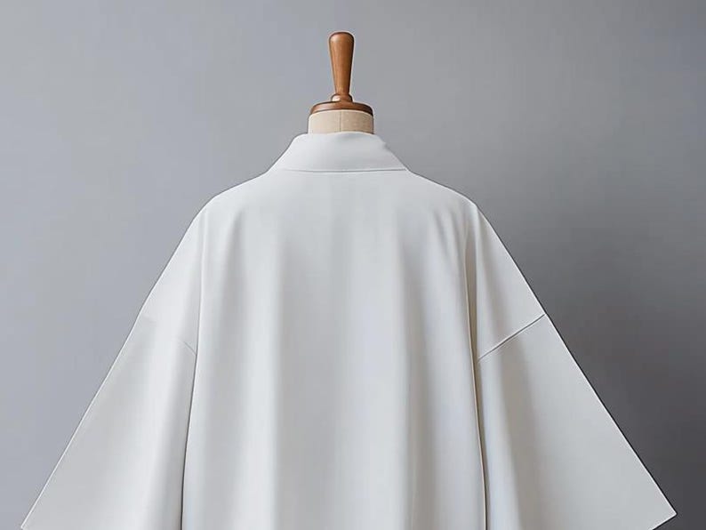 May include: A white long-sleeved shirt with a collar and a relaxed fit.