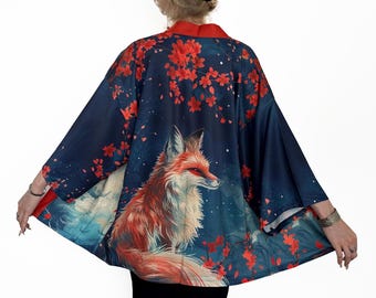 May include: A blue kimono with a red fox and cherry blossom print. The fox is in the centre of the kimono and is facing to the right. The cherry blossoms are scattered around the fox.