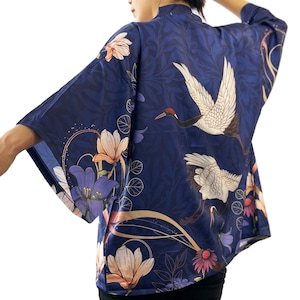 Puede incluir: Un kimono azul marino con estampado floral y de gr&uacute;as. El kimono tiene una silueta amplia y fluida y es perfecto para superponer sobre un atuendo sencillo.