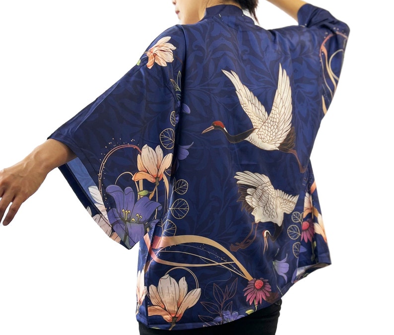 Puede incluir: Un kimono azul marino con estampado floral y de gr&uacute;as. El kimono tiene una silueta amplia y fluida y es perfecto para superponer sobre un atuendo sencillo.