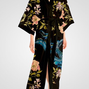 May include: Black silk robe with a floral and dragon print. The robe has a long, flowing silhouette and a tie belt.