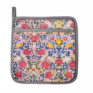May include: A gray and white pot holder with a floral pattern featuring red, yellow, and blue flowers. The pot holder has a pocket on the front.