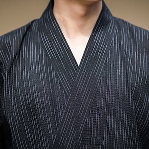 May include: A black and white striped kimono with a V-neck collar.