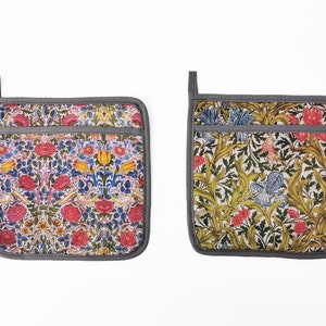 May include: Two gray and white floral patterned pot holders with a gray border. The pot holders have a pocket on the front.