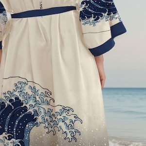 May include: A white robe with a blue and white wave design. The robe has a blue sash and the text "神奈川沖浪裏" is printed on the back.