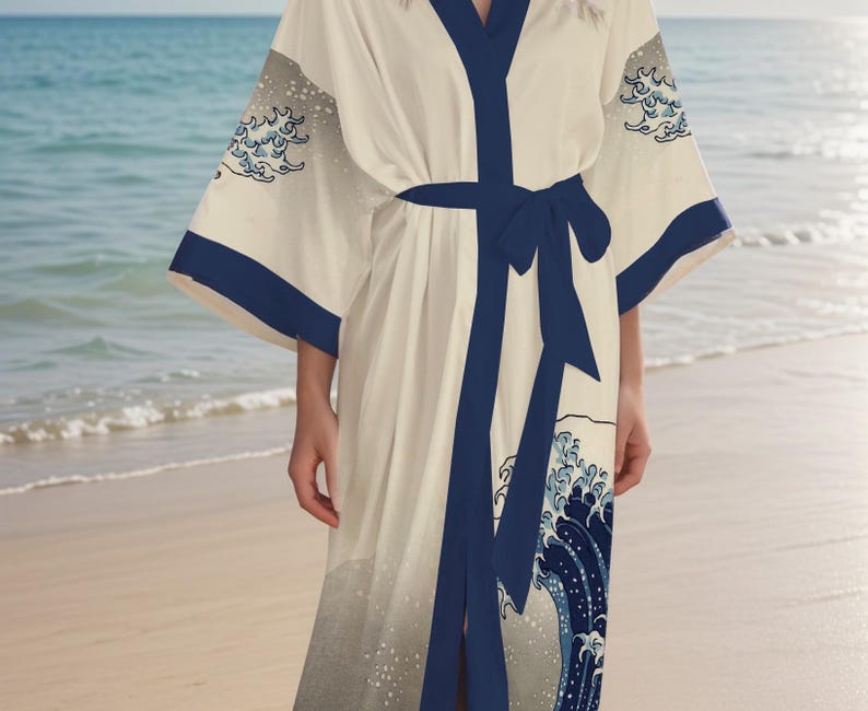 May include: A white robe with a blue and white wave pattern. The robe has a navy blue sash and is tied at the waist. The robe is made of a soft, silky material.