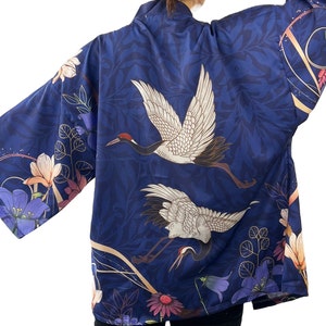 Puede incluir: Un kimono azul marino con un patr&oacute;n floral con gr&uacute;as y flores. El kimono tiene un dise&ntilde;o japon&eacute;s tradicional.