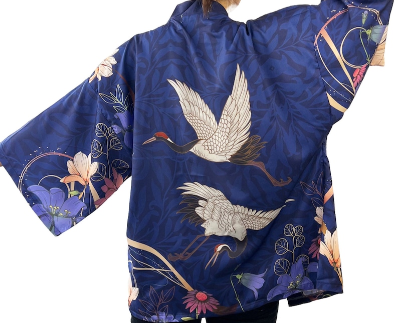 Puede incluir: Un kimono azul marino con un patr&oacute;n floral con gr&uacute;as y flores. El kimono tiene un dise&ntilde;o japon&eacute;s tradicional.